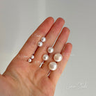 Hand holding various pearls with measurements on a plain background, branded 'Luna Studs'. | Ikecho Australia